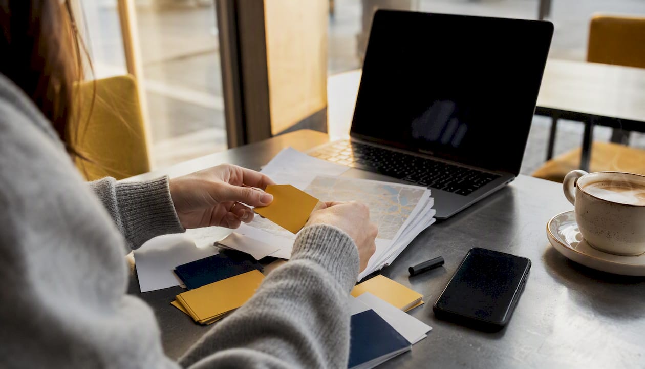 1785828306713_Hands-arranging-service-area-maps-and-cards-on-desk Hands arranging service area maps and cards on desk
