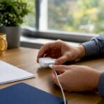 Hand adjusting device cable on desk