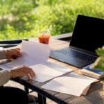 Close-up of hands arranging marketing papers on desk