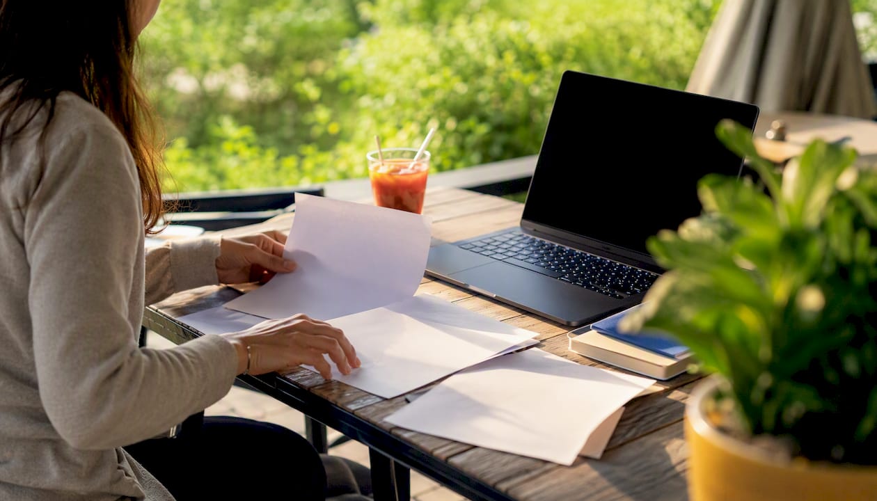 Close-up of hands arranging marketing papers on desk
