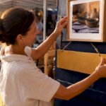 Business owner placing photo and sign in storefront