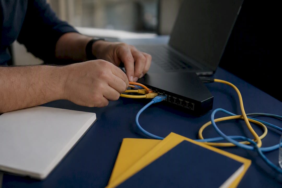 Hands wiring network hub cables on desk